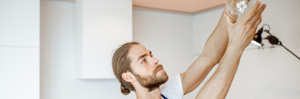 handyman installing light fixture